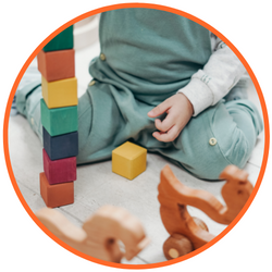 Child playing with rainbow-colored blocks